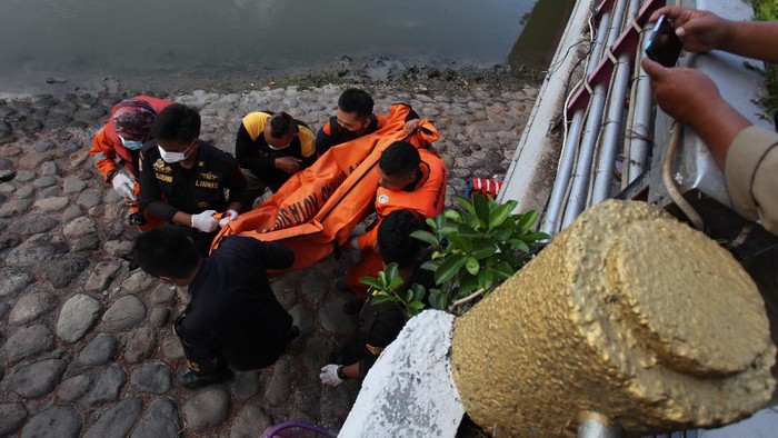 Petugas mencari seorang anak yang tenggelam di Sungai Kalimas, Surabaya, Jawa Timur, Rabu (20/10/2021). Petugas dari Tim Rescue Dinas Pemadam Kebakaran Kota Surabaya bersama instansi terkait dan warga mengevakuasi anak tenggelam yang diduga terpeleset saat bermain bersama empat temannya di pinggiran sungai itu. ANTARA FOTO/Didik Suhartono/aww.