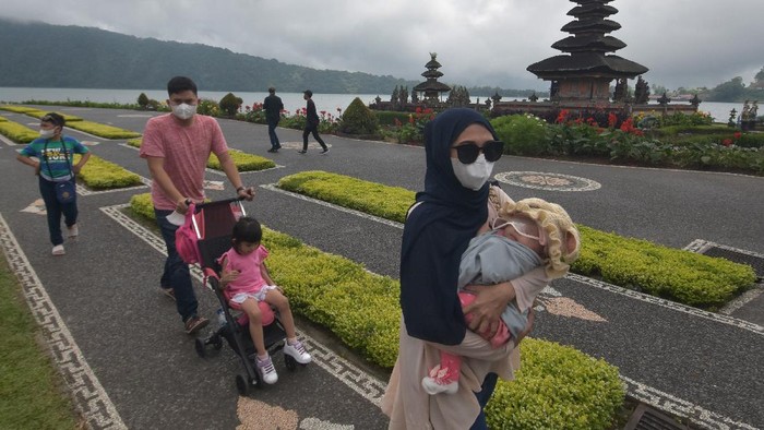 Wisatawan menikmati pemandangan objek wisata Ulun Danu Beratan saat liburan Maulid Nabi Muhammad SAW di Tabanan, Bali, Rabu (20/10/2021). Jumlah kunjungan wisatawan di objek wisata tersebut mengalami peningkatan dengan rata-rata 300 orang pada hari libur dan 100 orang pada hari biasa yang didominasi wisatawan domestik sejak dibuka pada Jumat (10/9/2021). ANTARA FOTO/Nyoman Hendra Wibowo/aww.