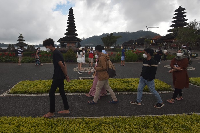 Wisatawan menikmati pemandangan objek wisata Ulun Danu Beratan saat liburan Maulid Nabi Muhammad SAW di Tabanan, Bali, Rabu (20/10/2021). Jumlah kunjungan wisatawan di objek wisata tersebut mengalami peningkatan dengan rata-rata 300 orang pada hari libur dan 100 orang pada hari biasa yang didominasi wisatawan domestik sejak dibuka pada Jumat (10/9/2021). ANTARA FOTO/Nyoman Hendra Wibowo/aww.