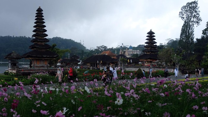 Wisatawan menikmati pemandangan objek wisata Ulun Danu Beratan saat liburan Maulid Nabi Muhammad SAW di Tabanan, Bali, Rabu (20/10/2021). Jumlah kunjungan wisatawan di objek wisata tersebut mengalami peningkatan dengan rata-rata 300 orang pada hari libur dan 100 orang pada hari biasa yang didominasi wisatawan domestik sejak dibuka pada Jumat (10/9/2021). ANTARA FOTO/Nyoman Hendra Wibowo/aww.