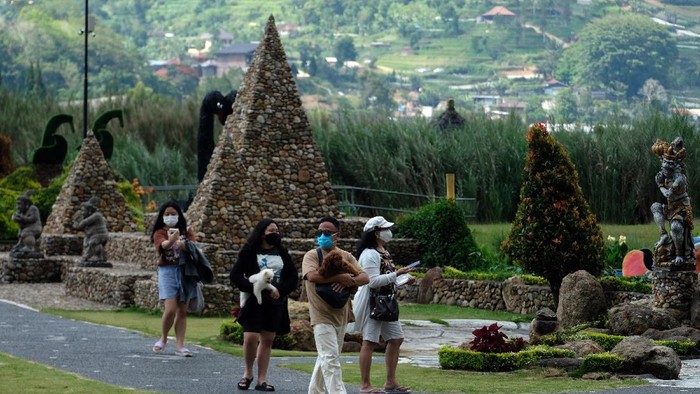 KUNJUNGAN WISATA DI ULUN DANU BERATAN BALI Wisatawan menikmati pemandangan objek wisata Ulun Danu Beratan saat liburan Maulid Nabi Muhammad SAW di Tabanan, Bali, Rabu (20/10/2021). Jumlah kunjungan wisatawan di objek wisata tersebut mengalami peningkatan dengan rata-rata 300 orang pada hari libur dan 100 orang pada hari biasa yang didominasi wisatawan domestik sejak dibuka pada Jumat (10/9/2021). ANTARA FOTO/Nyoman Hendra Wibowo/aww.