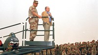 Jenderal Colin Powell mendampingi Menteri Pertahanan Dick Cheney dalam sebuah acara di pangkalan militer AS di Arab Saudi, (12/12/1990).  (AP Photo/Bob Daugherty, file)