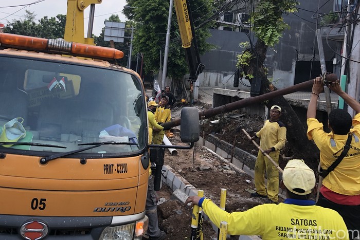 Sejumlah petugas menurunkan tiang utilitas di perempatan Blok S, Jakarta Selatan. Upaya itu bagian dari revitalisasi pedestrian.