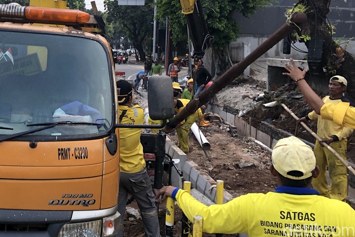 Sejumlah petugas menurunkan tiang utilitas di perempatan Blok S, Jakarta Selatan. Upaya itu bagian dari revitalisasi pedestrian.