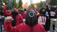 Pendemo beraksi di jalanan kota Seoul menggunakan kostum dalam karakter film Squid Game, serial populer di Netflix. Mereka menuntut perbaikan keselamatan dan keamanan pekerja.