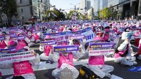 Sebagian pendemo menggunakan baju hazmat.