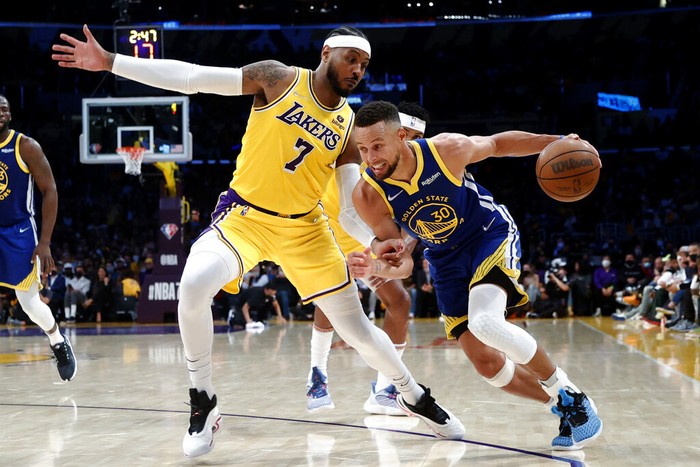 Golden State Warriors guard Stephen Curry (30) drives against Los Angeles Lakers forward Carmelo Anthony (7) during the second half of an NBA basketball game in Los Angeles, Tuesday, Oct. 19, 2021. The Warriors won 121-114. (AP Photo/Ringo H.W. Chiu)