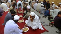 Perayaan Maulid Nabi ini pun dimanfaatkan warga untuk berbagi, salah satunya dengan membagikan makanan gratis kepada warga yang kurang mampu. AP Photo/Muhammad Sajjad.