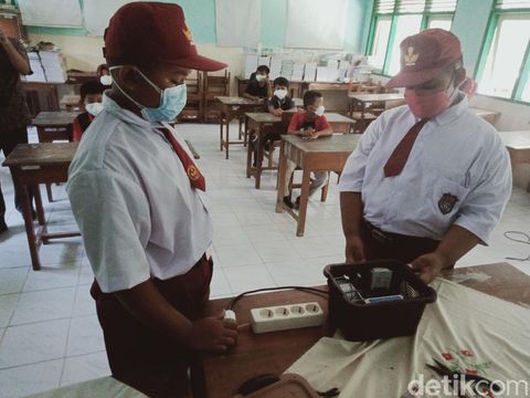 Dua siswa SDN 2 Butuhan menunjukkan alat Mesin Ozon Generator penangkan COVID-19