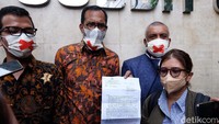 Haris Azhar dkk menunjukkan surat penjadwalan ulang mediasi.