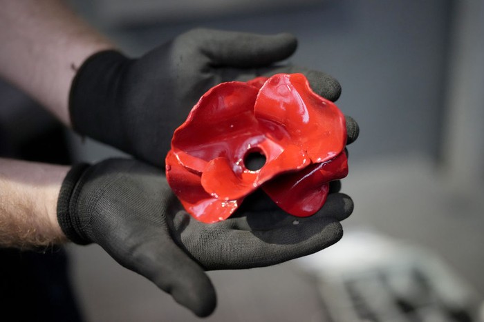 MANCHESTER, ENGLAND - OCTOBER 20: An engineer holds a ceramic poppy from the installation of 