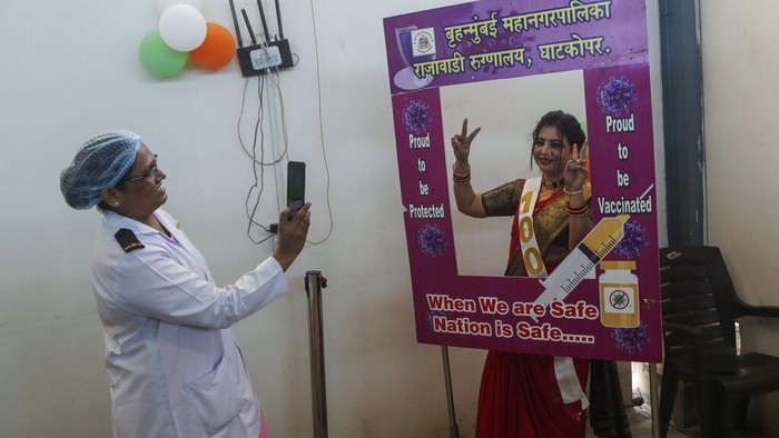 Health workers celebrate with vaccine beneficiaries India administering 1 billion doses of COVID-19 vaccine, at Rajawadi hospital in Mumbai, India, Thursday, Oct. 21, 2021. India has administered 1 billion doses of COVID-19 vaccine, passing a milestone for the South Asian country where the delta variant fueled its first crushing surge this year. (AP Photo/Rajanish Kakade)