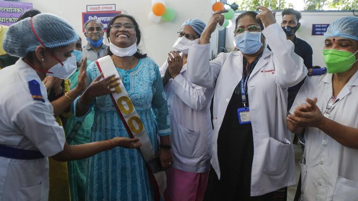 Health workers celebrate with vaccine beneficiaries India administering 1 billion doses of COVID-19 vaccine, at Rajawadi hospital in Mumbai, India, Thursday, Oct. 21, 2021. India has administered 1 billion doses of COVID-19 vaccine, passing a milestone for the South Asian country where the delta variant fueled its first crushing surge this year. (AP Photo/Rajanish Kakade)