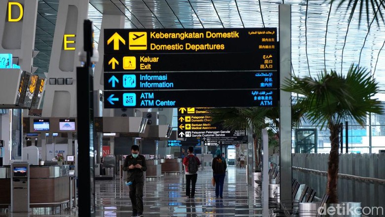 Naik Pesawat Harus PCR atau Antigen? Ini Beda Aturan Jawa Bali-Luar Jawa Bali JAKARTA, INDONESIA - APRIL 25: Airline and airport staff walk though the nearly empty Soekarno-Hatta International Airport on April 25, 2020 in Jakarta, Indonesia. As Muslims mark the start of Ramadan, Indonesia announced a temporary ban on nearly all travel into and out of the country including by air, boat, train and road to prevent the spread of COVID-19. (Photo by Ed Wray/Getty Images)