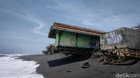 Sebuah bangunan Tempat Pelelangan Ikan (TPI) di dekat bibir pantai terancam ambruk. Hampir separuh bagian bawah bangunan tidak lagi ditopang oleh pasir lantaran tergerus ombak pasang. (Jalu Rahman Dewantara/detikTravel)