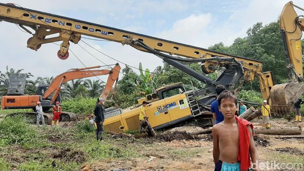 Sebuah crane yang digunakan pada proyek instalasi pengolahan air limbah (IPAL) Pekanbaru, Riau amblas. Akibatnya, jalan yang menjadi akses warga terganggu. (Raja Adil/detikcom)