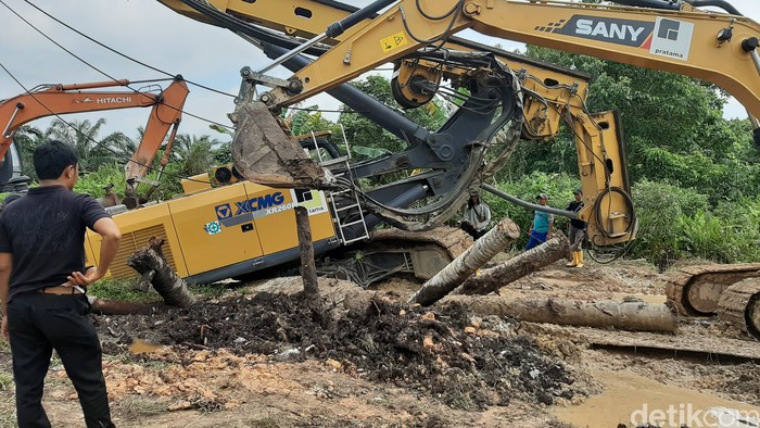 Sebuah crane yang digunakan pada proyek instalasi pengolahan air limbah (IPAL) Pekanbaru, Riau amblas. Akibatnya, jalan yang menjadi akses warga terganggu. (Raja Adil/detikcom)