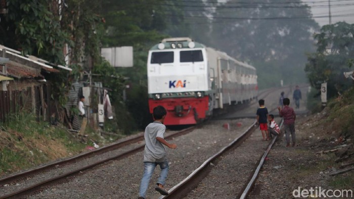 Seorang anak terlihat sedang berlari di atas rel kereta api Bandung.