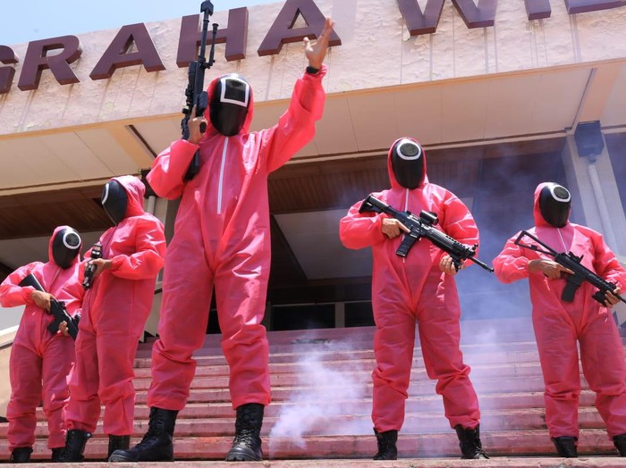Belasan pink soldier ala Squid Game muncul dalam Seleksi Kompetensi Dasar (SKD) CPNS Kemenkumham Jatim. Bukan untuk ikut seleksi, tapi mereka mengawal para peserta di sela-sela tes Formasi Penjaga Tahanan dan Pemeriksa Keimigrasian.