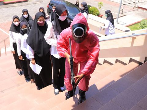 Belasan pink soldier ala Squid Game muncul dalam Seleksi Kompetensi Dasar (SKD) CPNS Kemenkumham Jatim. Bukan untuk ikut seleksi, tapi mereka mengawal para peserta di sela-sela tes Formasi Penjaga Tahanan dan Pemeriksa Keimigrasian.