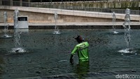 Petugas membersihkan air kolam yang ada di Lapangan Banteng. Bahkan petugas yang berjaga pun akan selalu meningatkan pengunjung untuk taat prokes.