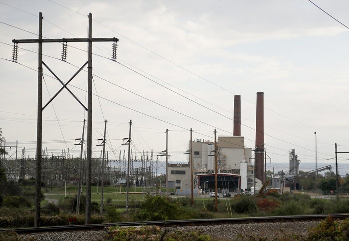 Cryptocurrency Power Plant CORRECTS SPELLING OF GREENIDGE - A brief patch of early morning sunlight brightens the landscape around the Greenidge Generation power plant on the banks of Seneca Lake, Friday, Oct. 15, 2021, in Dresden, N.Y. One Bitcoin mining operation in central New York came up with a novel solution in finding cheap energy to run the power-gobbling computer arrays that create and transact cryptocurrency: It took over Greenidge Generation which now produces about 44 megawatts to run 15,300 computer servers, plus additional electricity it sends into the state's power grid. (AP Photo/Julie Jacobson)