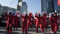Di pusat kota Seoul, para demonstran menentang pembatasan Covid-19, memprotes lebih banyak pekerjaan, dan kondisi kerja yang lebih baik sambil mengenakan pakaian dari serial Squid Game di Netflix. Foto: Dok. Twitter @quicktake