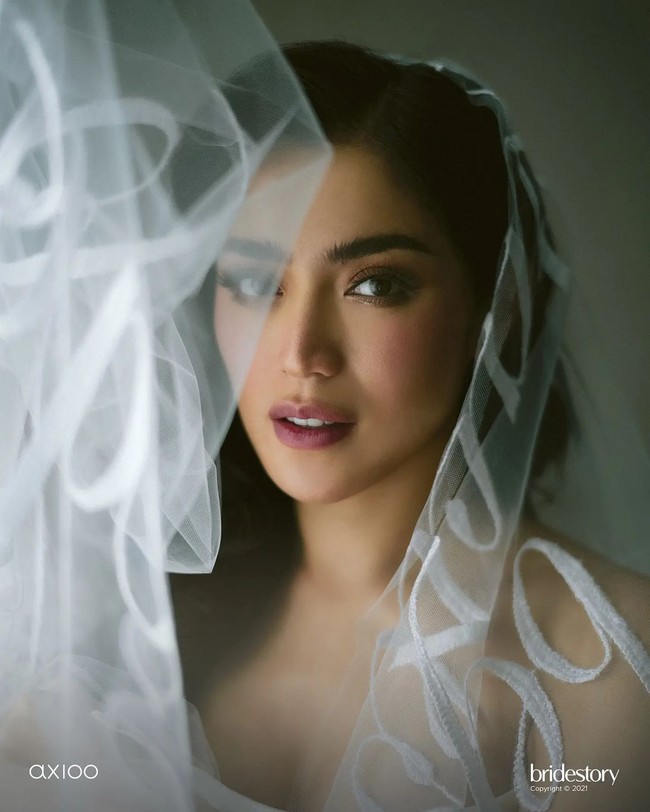 Dress rancangan Monica terlihat cantik sekaligus unik dengan detail spesial yakni veil sepanjang lima meter dengan sulaman kata-kata dari wedding vow-nya. Monica mendesain gaun putih dengan bustier itu sesuai permintaan Jedar yang menginginkan look whimsical, seksi, sekaligus elegan.Foto: Instagram @thebridestory