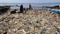 Nelayan beraktivitas di antara tumpukan sampah di pantai Sukaraja Bandar Lampung, Lampung, Jumat (22/10/2021).
