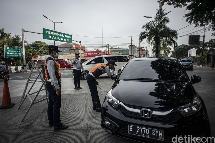 Polisi Lalu Lintas bersama Petugas Dishub DKI Jakarta mengatur arus lalu lintas di depan pintu masuk Taman Margasatwa Ragunan, Jakarta, Sabtu (23/10/2021). Dinas Perhubungan DKI Jakarta menerapkan kebijakan pelat nomor polisi ganjil genap pada kendaraan roda empat di tempat wisata edukasi Taman Margasatwa Ragunan yang berlaku mulai 22 Oktober 2021 saat penerapan Pemberlakuan Pembatasan Kegiatan Masyarakat (PPKM) level dua di Ibu Kota. ANTARA FOTO/Aprillio Akbar/wsj.