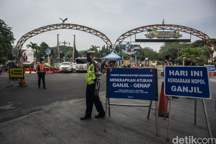 Polisi Lalu Lintas bersama Petugas Dishub DKI Jakarta mengatur arus lalu lintas di depan pintu masuk Taman Margasatwa Ragunan, Jakarta, Sabtu (23/10/2021). Dinas Perhubungan DKI Jakarta menerapkan kebijakan pelat nomor polisi ganjil genap pada kendaraan roda empat di tempat wisata edukasi Taman Margasatwa Ragunan yang berlaku mulai 22 Oktober 2021 saat penerapan Pemberlakuan Pembatasan Kegiatan Masyarakat (PPKM) level dua di Ibu Kota. ANTARA FOTO/Aprillio Akbar/wsj.