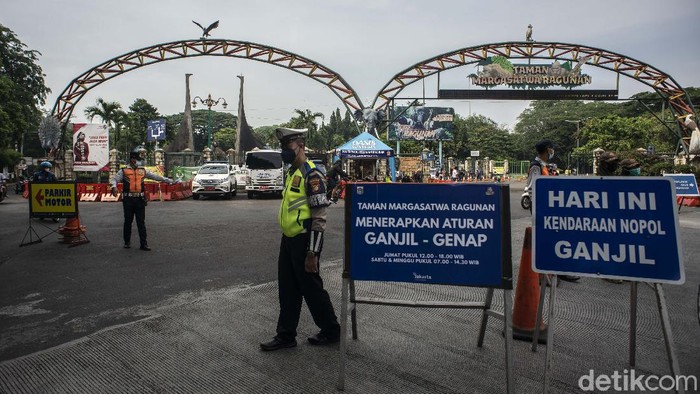 Polisi Lalu Lintas bersama Petugas Dishub DKI Jakarta mengatur arus lalu lintas di depan pintu masuk Taman Margasatwa Ragunan, Jakarta, Sabtu (23/10/2021). Dinas Perhubungan DKI Jakarta menerapkan kebijakan pelat nomor polisi ganjil genap pada kendaraan roda empat di tempat wisata edukasi Taman Margasatwa Ragunan yang berlaku mulai 22 Oktober 2021 saat penerapan Pemberlakuan Pembatasan Kegiatan Masyarakat (PPKM) level dua di Ibu Kota. ANTARA FOTO/Aprillio Akbar/wsj.