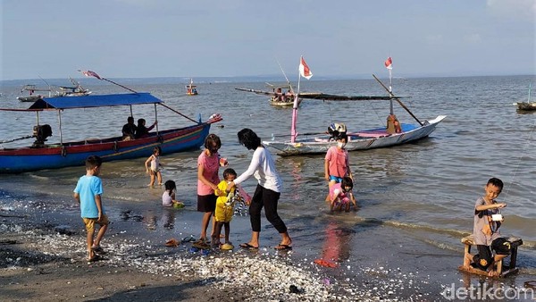 Sejumlah pengunjung bermain air di Pantai Kanjeran, Surabaya, Jawa Timur, Minggu (24/10/2021).