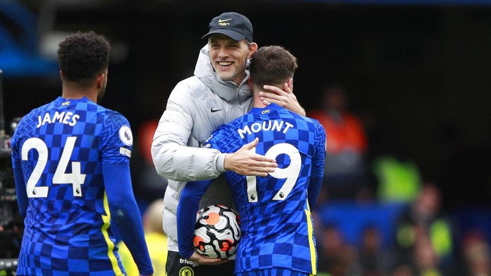 Chelseas head coach Thomas Tuchel, center, celebrates with Chelseas Mason Mount, right, at the end of the English Premier League soccer match between Chelsea and Norwich City at Stamford Bridge Stadium in London, Saturday, Oct. 23, 2021. (AP Photo/Ian Walton)