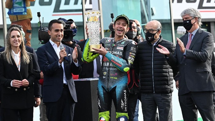 Yamaha-SRT Italian rider Valentino Rossi (C) holds a lifetime career award handed to him by Italys Foreign Affairs Minister, Luigi Di Maio (L) on October 24, 2021 after the Emilia-Romagna MotoGP Grand Prix at the Misano World Circuit Marco-Simoncelli in Misano Adriatico, Italy. - Valentino Rossi, who will retire at the end of the season, made his last home appearance at the Emilia-Romagna MotoGP in Misano. (Photo by ANDREAS SOLARO / AFP)