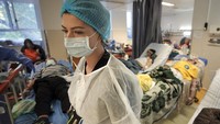 Para tenaga kesehatan di sejumlah rumah sakit Rumania pun tampak berjibaku dan tak kenal lelah merawat para pasien COVID-19. AP Photo/Vadim Ghirda. 