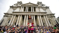 Penampakan boneka raksasa yang dikenal dengan sebutan Little Amal disambut ratusan warga saat tiba di kota London, Inggris, Sabtu (23/10/2021). Aaron Chown/PA via AP.