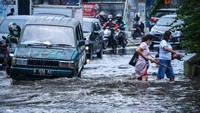 Pengendara dan warga melintasi genangan di kawasan Palmerah, Jakarta, Senin (25/10/2021). ANTARA FOTO/Rivan Awal Lingga  