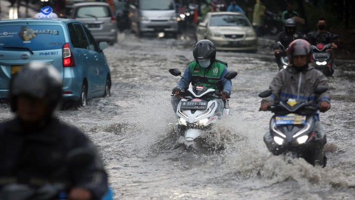 Pengendara menerobos banjir di Jalan Raya Kebayoran Lama, Jakarta, Senin (25/10/2021). Banjir yang menggenangi jalan setinggi lutut orang dewasa itu disebabkan karena drainase buruk saat terjadi hujan deras. ANTARA FOTO/Muhammad Iqbal/rwa.