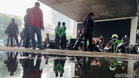 Para pengendara sepeda motor terpaksa berteduh karena hujan deras mengguyur kawasan Slipi, Jakarta.