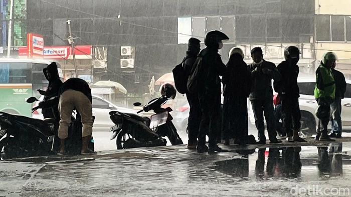 Hujan lebat mengguyur wilayah DKI Jakarta, Senin (25/10/2021) siang. Para pengendara sepeda motor pun langsung menepi untuk berteduh di kolong jembatan.