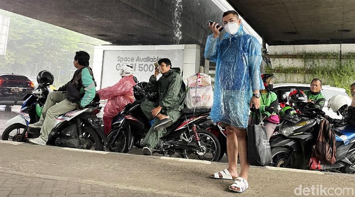 Hujan lebat mengguyur wilayah DKI Jakarta, Senin (25/10/2021) siang. Para pengendara sepeda motor pun langsung menepi untuk berteduh di kolong jembatan.