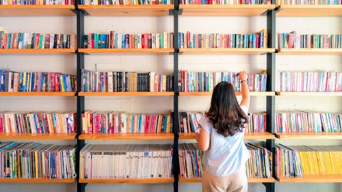 Asian women are picking up books on the bookshelf. To prepare to back to school