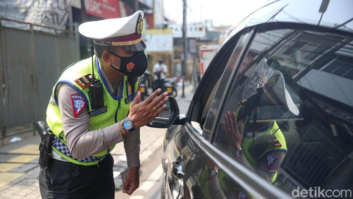 Sejumlah Polisi melakukan sosialisasi terhadap kendaraan roda empat di kawasan Jalan Fatmawati, Jakarta, Senin (25/10/2021). Kawasan ganjil-genap di Jakarta diperluas menjadi 13 titik. Ganjil-genap itu mulai berlaku hari ini.