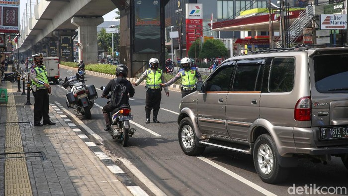 Kini Ganjil-Genal Juga Diterapkan di Jalan Fatmawati Sejumlah Polisi melakukan sosialisasi terhadap kendaraan roda empat di kawasan Jalan Fatmawati, Jakarta, Senin (25/10/2021). Kawasan ganjil-genap di Jakarta diperluas menjadi 13 titik. Ganjil-genap itu mulai berlaku hari ini.