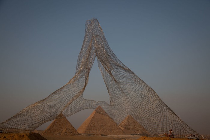 Pameran Seni Kontemporer Digelar di Piramida Mesir CAIRO, EGYPT - OCTOBER 23: An installation titled Together on display at the Great Pyramids of Giza on October 23, 2021 in Cairo, Egypt. The exhibition, presented by the organization Art D'Egypte in partnership with the Egyptian Ministry of Antiquities and Tourism, features a sculpture trail around the Giza plateau with works by Egyptian and foreign contemporary artists. (Photo by Sima Diab/Getty Images)