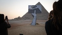 Karya seni yang mejeng di pelataran Piramida Giza ini jelas menarik turi-turis untuk mendekat.   