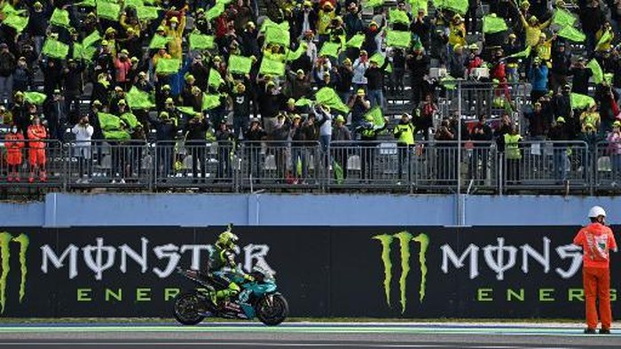 Yamaha-SRT Italian rider Valentino Rossi rides past to acknowledge his fan on October 24, 2021 after the Emilia-Romagna MotoGP Grand Prix at the Misano World Circuit Marco-Simoncelli in Misano Adriatico, Italy. - Valentino Rossi, who will retire at the end of the season, made his last home appearance at the Emilia-Romagna MotoGP in Misano. (Photo by ANDREAS SOLARO / AFP)