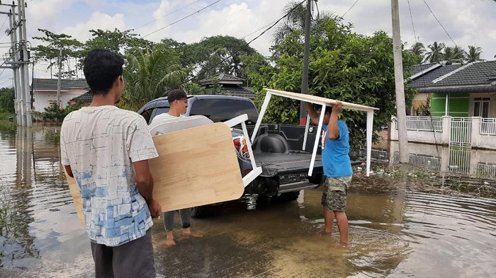 Warga evakuasi barang-barang dari rumah yang terendam banjir (Raja-detikcom)