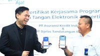 Plt Direktur Utama PT Asuransi Kredit Indonesia atau Askrindo Liston Simanjuntak bersama Direktur Utama PT Djelas Tandatangan Bersama atau TekenAja! Alwin Jabarti Kiemas menunjukkan aplikasi TekenAja! pada gawai usai melakukan penandatanganan kerja sama Layanan Tanda Tangan Elektronik, di Jakarta, Selasa (26/10/2021). 